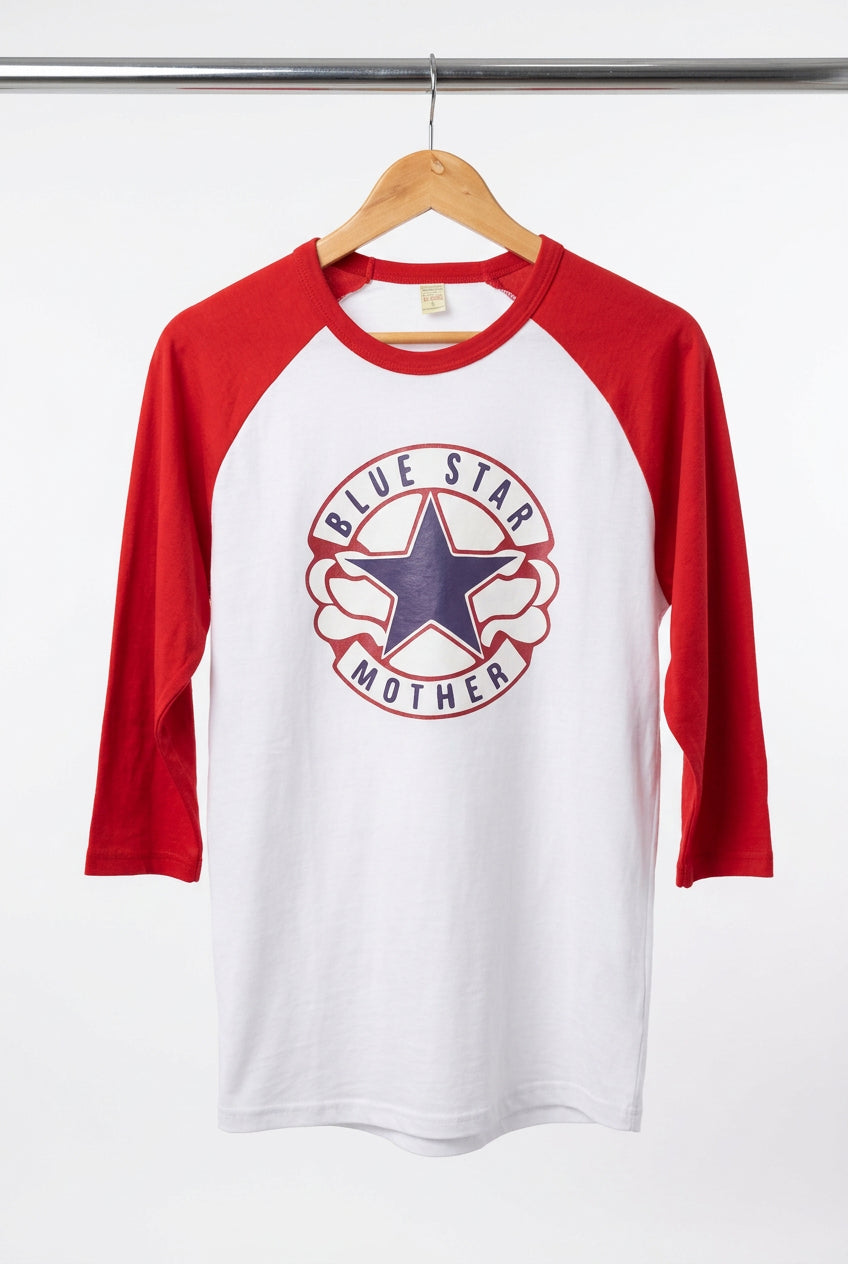 A red and white raglan baseball t-shirt hanging on a wooden hanger on a black wire display rack. The shirt features a circular 'Blue Star Mother' graphic on the chest with a blue star and red and white text.